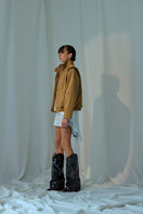 Light brown Lorena Saravia Katy suede jacket with a tailored fit and classic collar, displayed hanging on a neutral background.