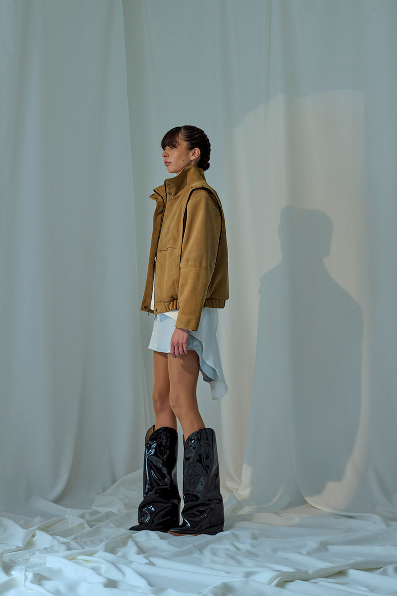 Light brown Lorena Saravia Katy suede jacket with a tailored fit and classic collar, displayed hanging on a neutral background.