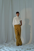 Light-colored Isabela blouse by Lorena Saravia, featuring stylish design details, displayed on a hanger against a neutral background.
