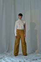 Lorena Saravia Serena wool pants in neutral beige, tailored fit with waistband and side pockets, on a plain background.
