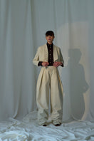 Lorena Saravia Alex wool pants in beige, tailored with a high waist and wide-leg design, shown on a model.