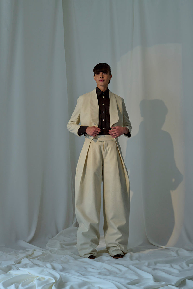 Lorena Saravia Alex wool pants in beige, tailored with a high waist and wide-leg design, shown on a model.