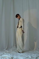 Lorena Saravia Alex wool pants in neutral fabric, tailored fit with front pockets, displayed on a model.