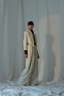 Lorena Saravia Alex wool pants in neutral color, tailored fit, with side pockets and waistband, displayed on a hanger.