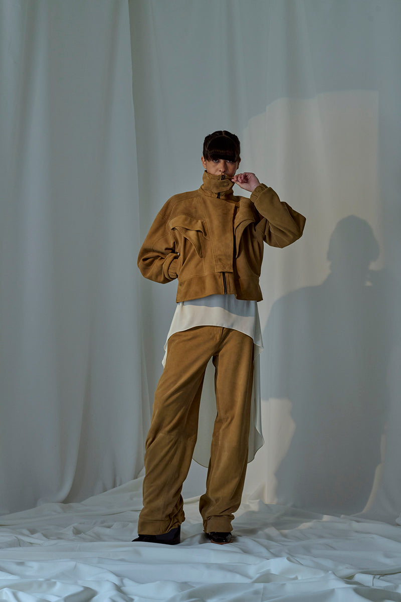 Lorena Saravia Julia suede pants in neutral color, showcasing their tailored fit and soft suede texture.