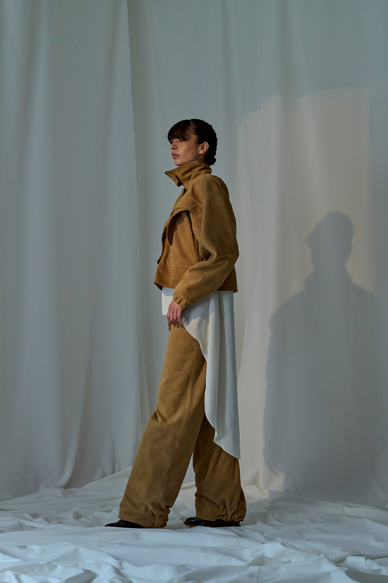 Lorena Saravia Julia suede pants in a stylish fit, shown in a neutral color, with a focus on the fabric and tailored design.