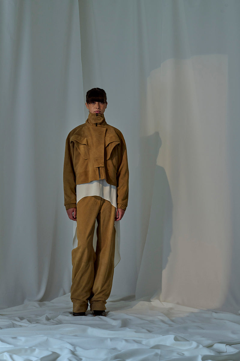 Lorena Saravia Julia suede pants in neutral color, showcasing their slim fit and smooth fabric texture.