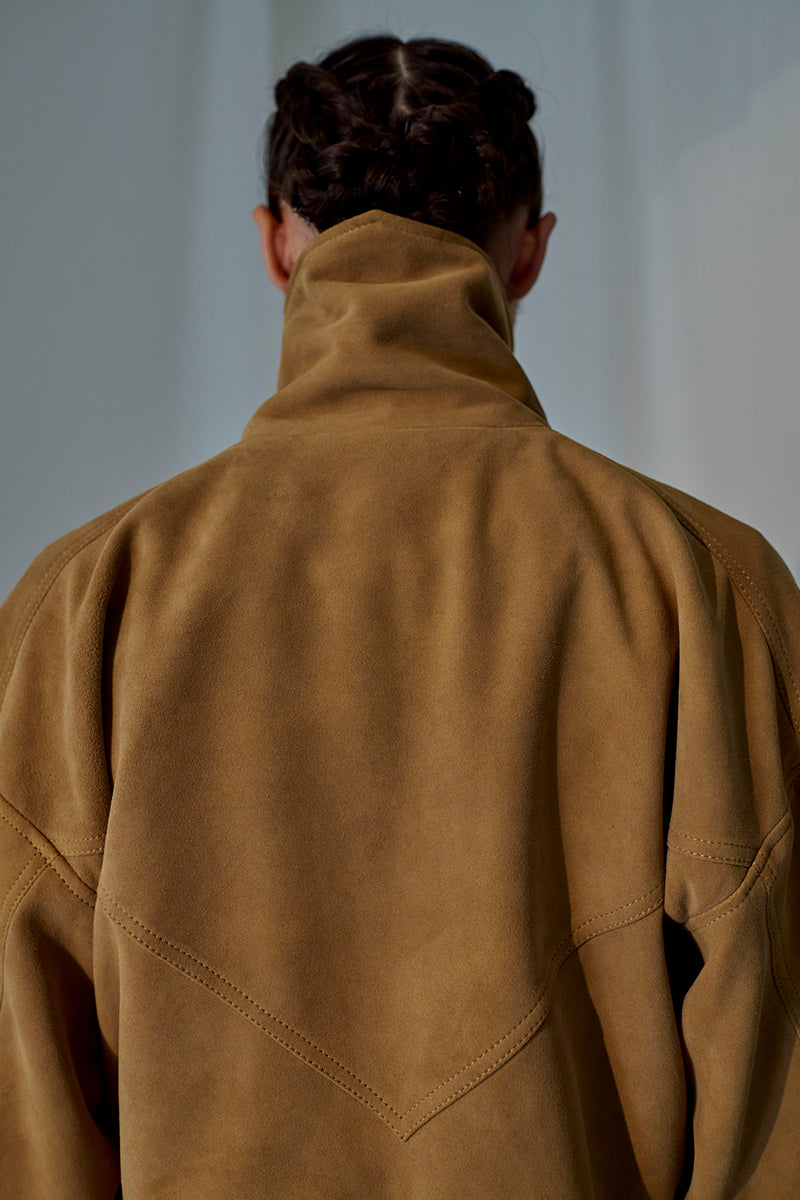 Lorena Saravia Julia suede jacket in neutral tones, showcasing its stylish collar and sleek design on a model.
