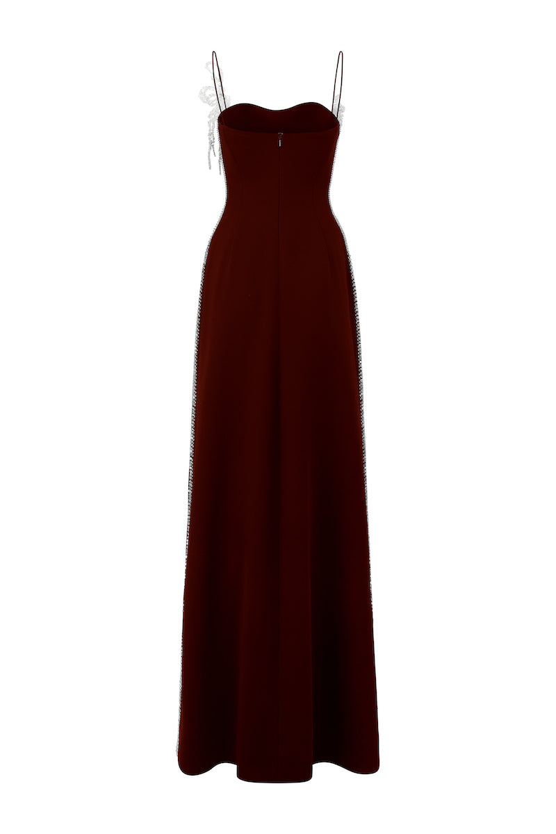 Red poly crepe spaghetti strap gown by L'SCARLETT featuring a sleek, elegant design with thin straps and a flowing silhouette.