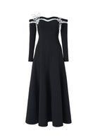 Black off-shoulder long-sleeve poly crepe gown by L'SCARLETT, featuring elegant draping and fitted silhouette.