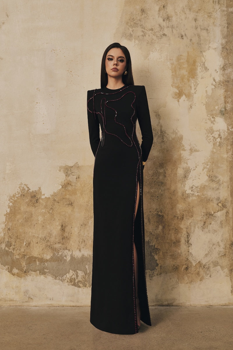 Black long-sleeve maxi dress with heart beading front slit from L'SCARLETT, featuring elegant design and flowing fabric.