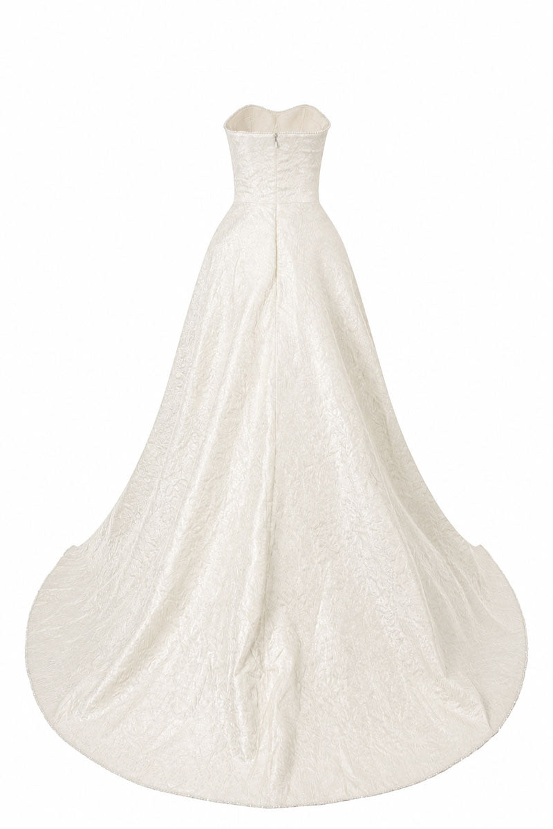 L'SCARLETT strapless off-white maxi dress with a floor-sweeping mullet overskirt, shown from the back.