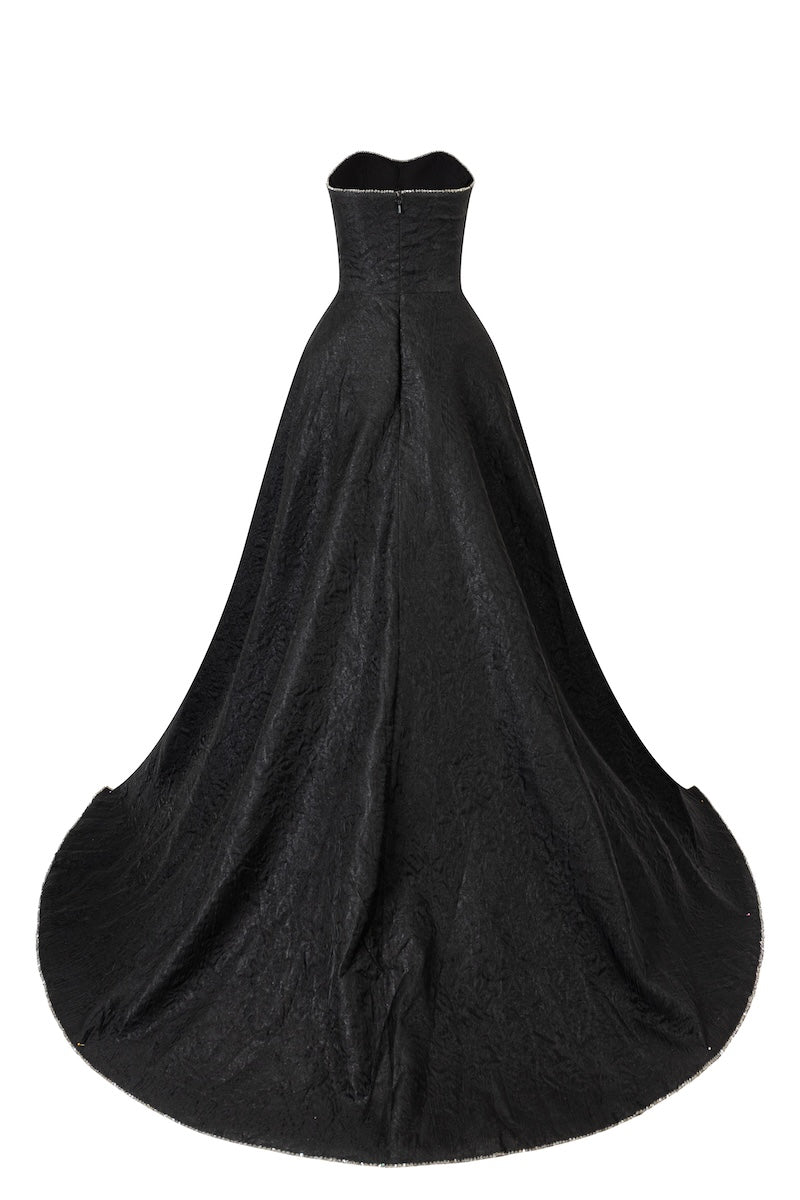 Black strapless floor-sweeping mullet overskirt maxi dress by L'SCARLETT, shown from the back with flowing fabric and elegant design.
