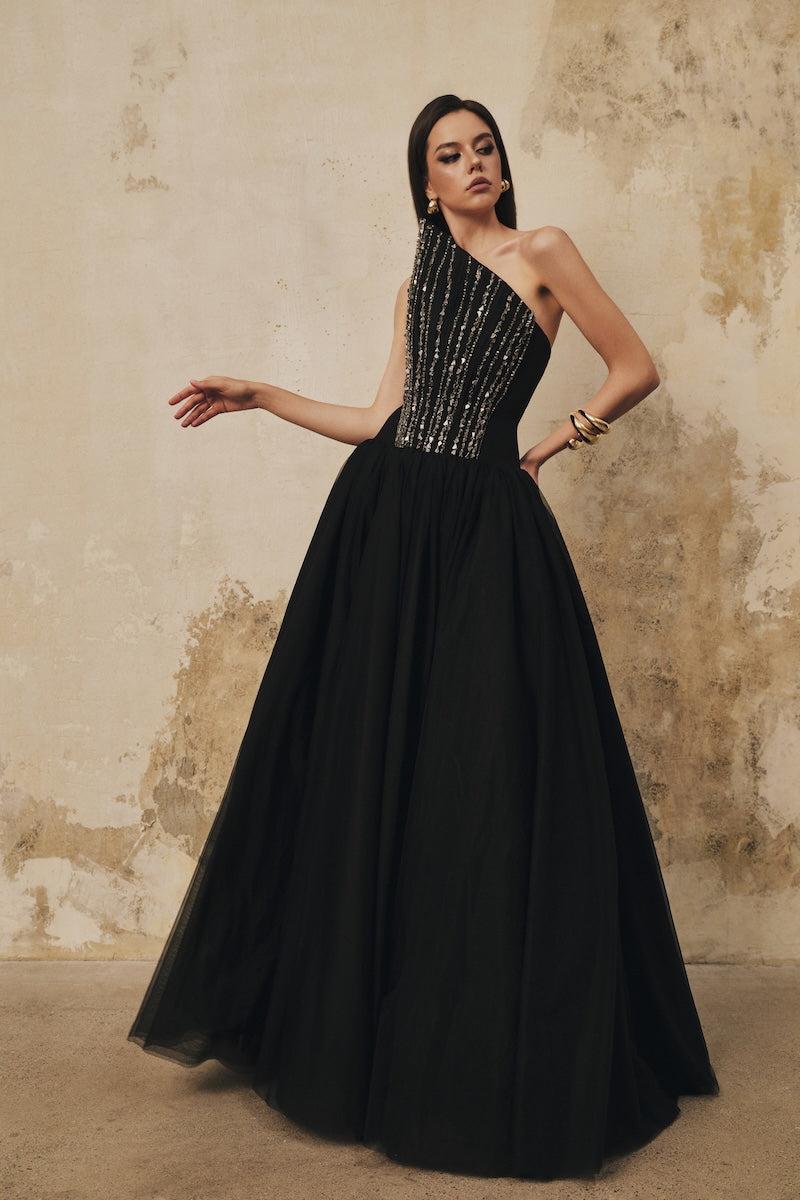 Black L'SCARLETT flared evening gown with pointed bustline, front draping, and crystal beading, perfect for formal occasions.