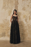 L'SCARLETT flared gown with wide shoulder straps and crystal beading, elegant evening dress displayed on a hanger.