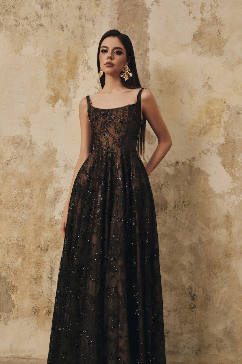Black L'SCARLETT flared maxi dress with wide shoulder straps and crystal beading, elegant and flowing.