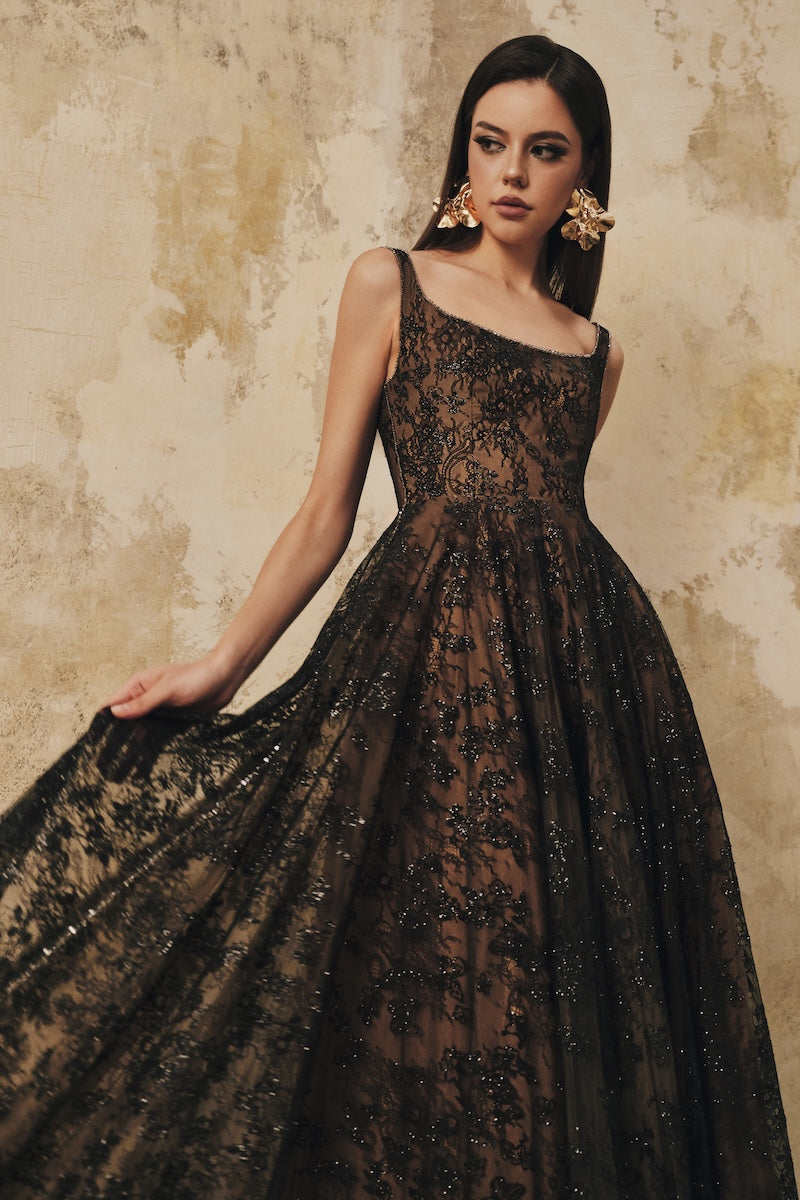 Black L'SCARLETT flared maxi dress with wide shoulder straps and crystal beading, elegant and flowing.