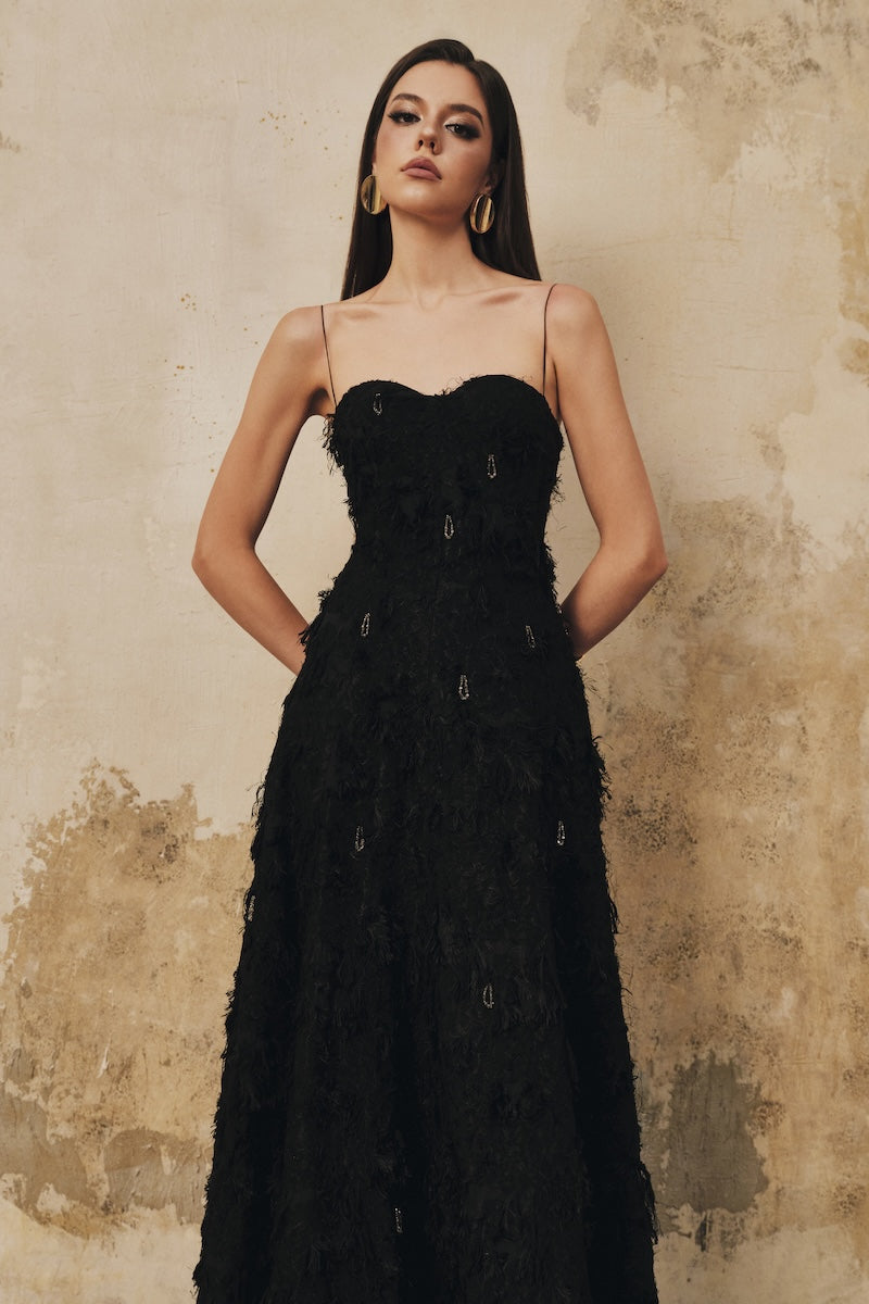 Black A-line spaghetti-strap midi dress with crystal beading by L'SCARLETT, featuring a fitted bodice and flowing skirt.