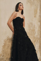 Black A-line spaghetti-strap gown with crystal beading by L'SCARLETT, elegant evening dress featuring a fitted bodice and flowing skirt.