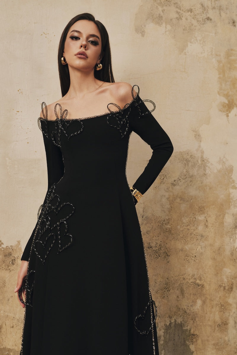Black flared off-shoulder long-sleeve midi dress by L'SCARLETT with heart beading details, stylish and elegant for special occasions.