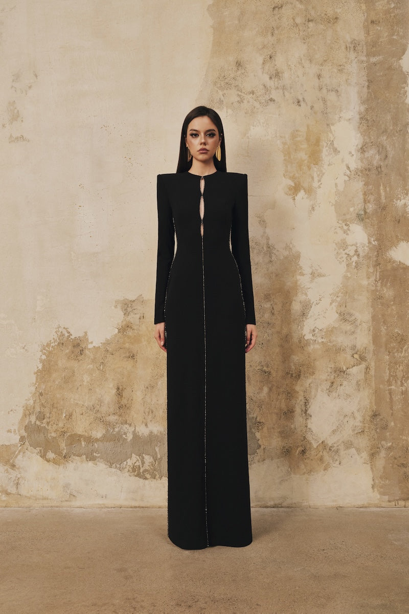 Black L'SCARLETT maxi dress with straight cut, long sleeves, and crystal beading for elegant evening wear.