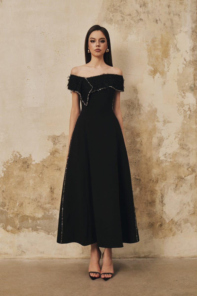 Black L'SCARLETT flared draped-neckline off-shoulder beaded midi dress shown with flowing fabric and elegant design details.