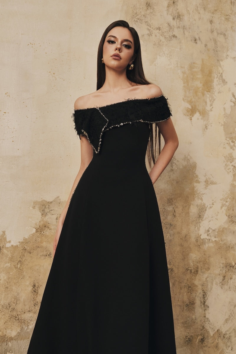 Black flared beaded midi dress with draped neckline and off-shoulder design by L'SCARLETT, shown on a model.