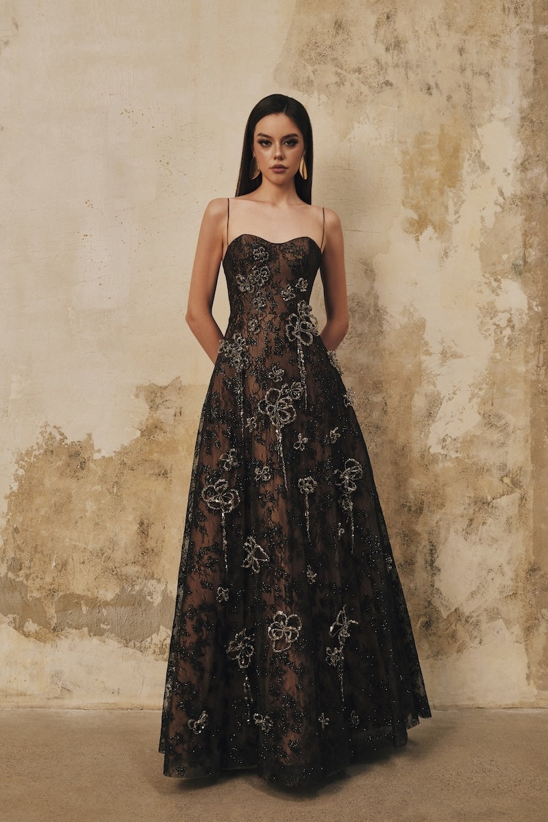 Black L'SCARLETT A-line spaghetti-strap maxi dress with 3D crystal floral embellishments, perfect for elegant occasions.