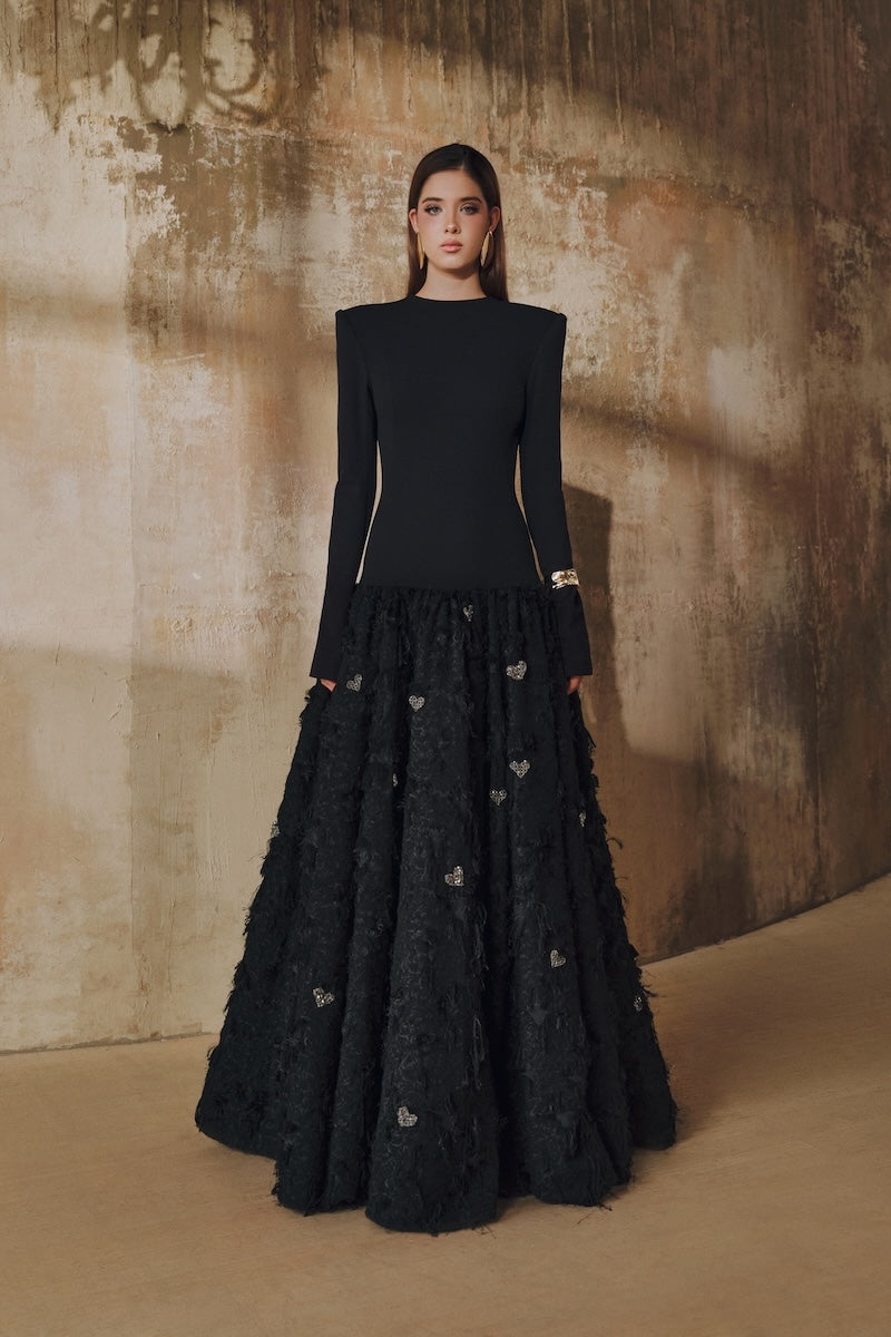 Black maxi dress by L'Scarlett featuring a round neck, open back, hand-embellished crystal heart design, elegant evening wear.