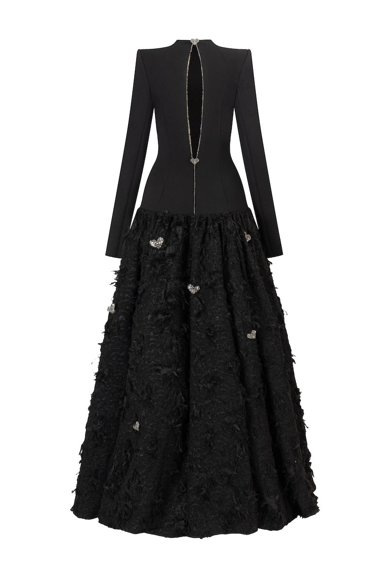 Black maxi dress by L'Scarlett featuring a round neck, open back, hand-embellished crystal heart design, elegant evening wear.