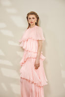 Le Thanh Hoa pink tiered gown featuring flowing fabric and layered design, perfect for elegant occasions.