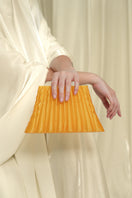 Touchless Liquid Treasures in Gold clutch with sleek design, featuring a shiny gold exterior and elegant wrist strap.