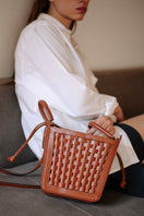 ISIDORA MALVA La Dorada Mini brown top handle bag with sleek design and compact size, shown in the image.