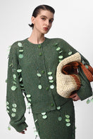 Hand-knit green maxi skirt with embellishments by Lalo, featuring intricate details and a flowing, stylish design.