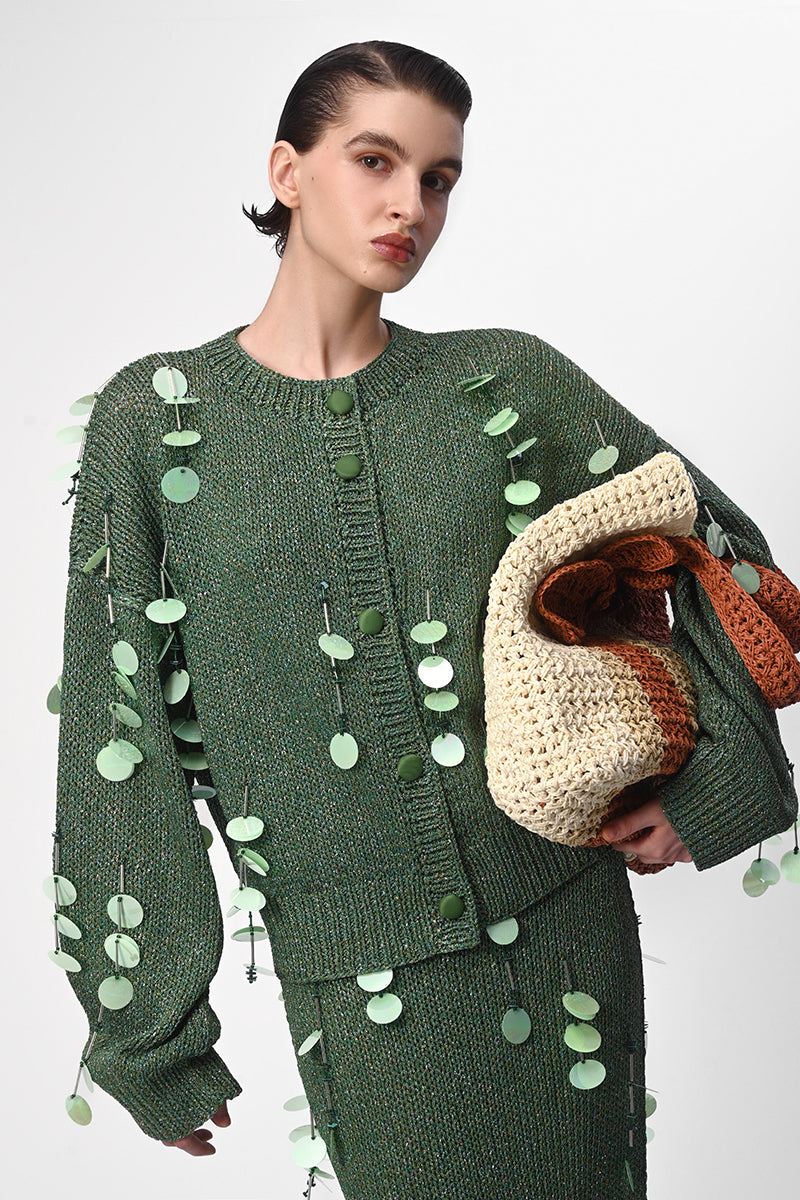 Hand-knit green maxi skirt with embellishments by Lalo, featuring intricate details and a flowing, stylish design.