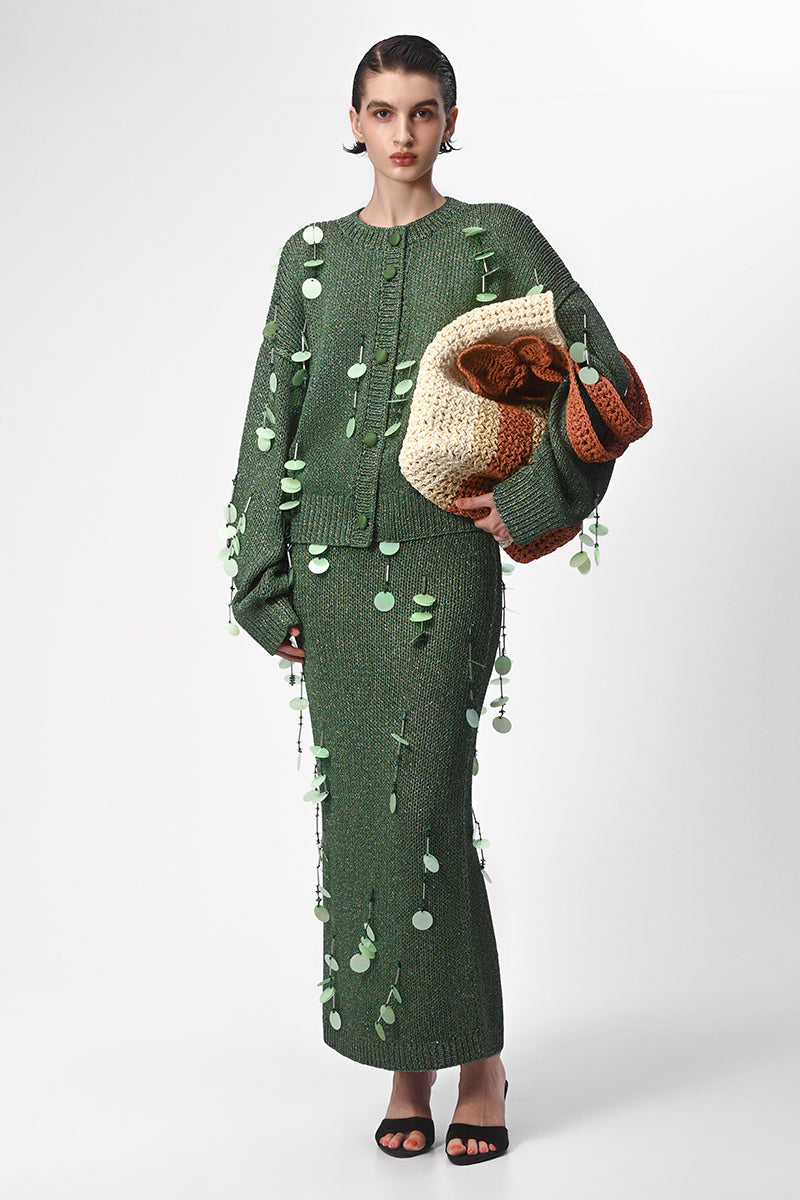 Hand-knit green maxi skirt with embellishments from Lalo, featuring intricate details and a flowing, stylish design.
