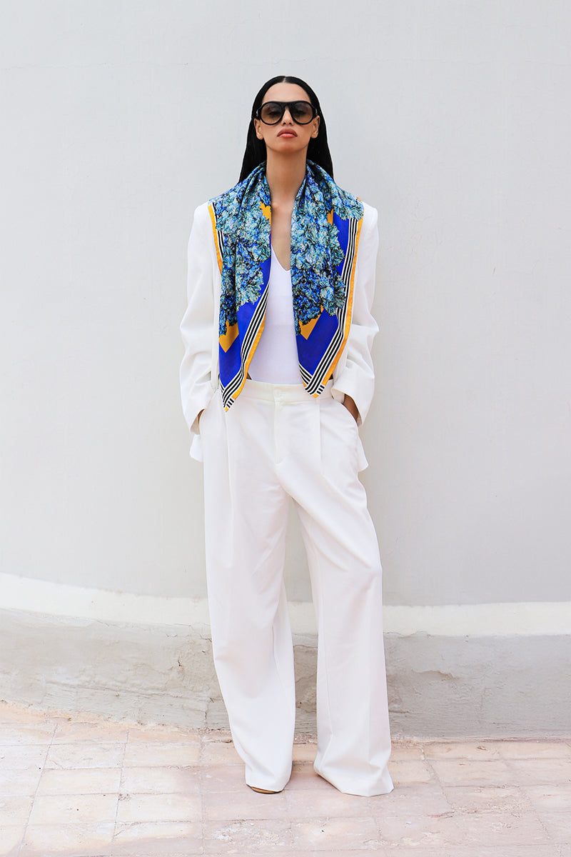 Silk scarf by Amel Batita featuring intricate patterns, draped elegantly showcasing its soft texture and vibrant design.