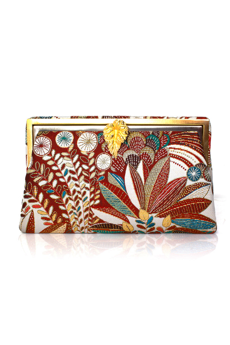 Multicolor Leaf of Brown Jungle Grace clutch by Sarah's Bag featuring a vibrant leaf design on a brown background.