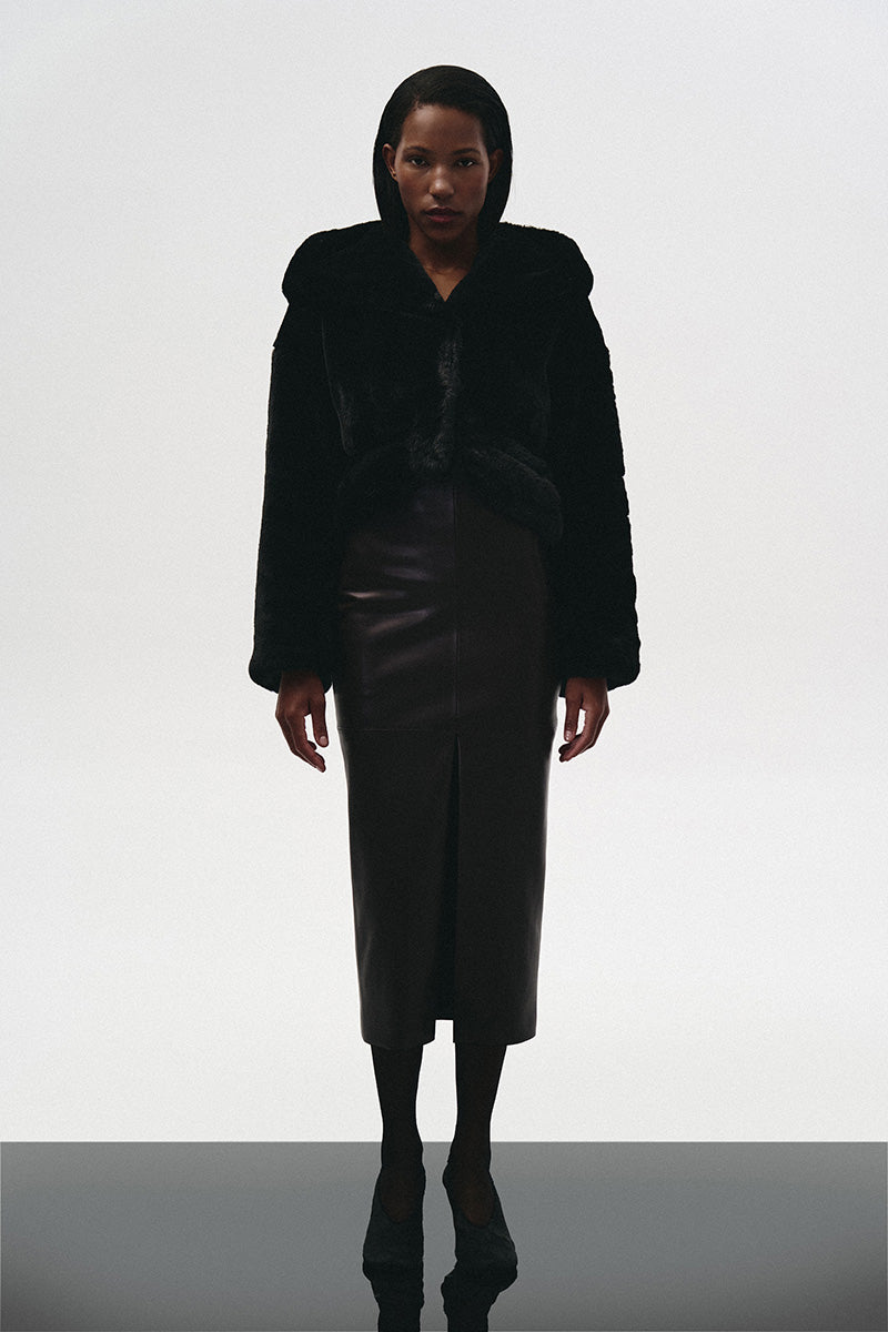 Brown leather midi skirt by Kris Marán, shown with front cut detail, styled for a chic, modern look.