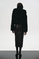 Back view of KRIS MARÁN brown leather midi skirt, showcasing its sleek fit and smooth texture.