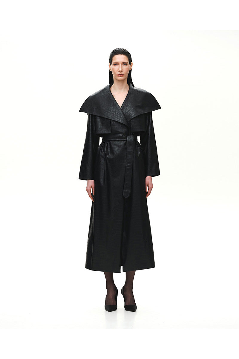Black leather trench coat with embossed crocodile pattern and buckle details by Kris Marán.