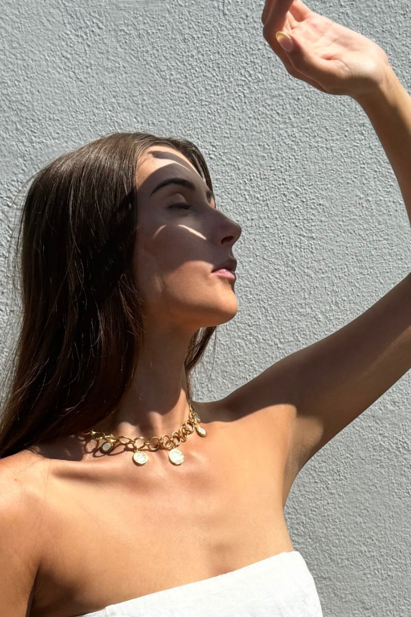 Freya Rose forged circular gold necklace worn as jewelry accessory in a lifestyle setting.
