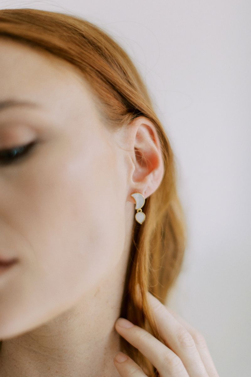 Freya Rose WARRIORESS PETITE MOON earrings in 18ct gold plated, shown styled as everyday jewelry in a lifestyle setting.