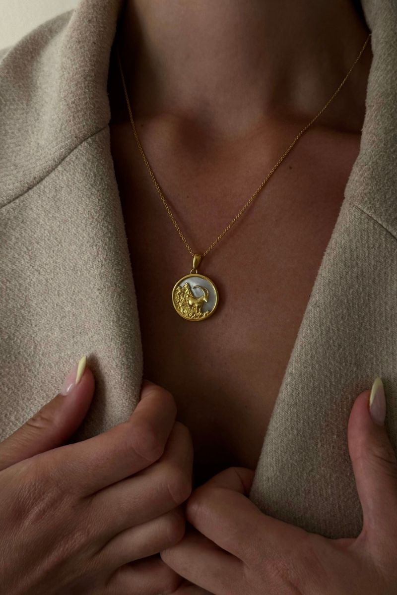 Freya Rose Capricorn 18ct gold plated zodiac necklace worn as jewelry in a lifestyle setting, showcasing a stylish gold pendant.