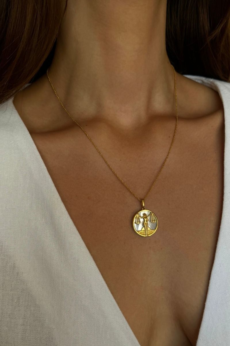Libra zodiac necklace by Freya Rose featuring 18k gold-plated pendant on a delicate chain, worn as everyday jewelry.