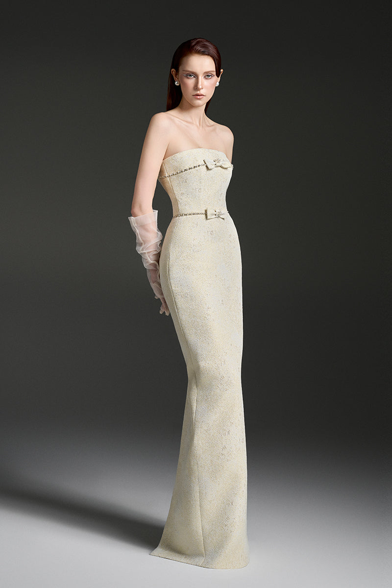 Light yellow strapless lacqured brocade gown by I.H.F Studio featuring pearl accents and crystal chain embellishments.