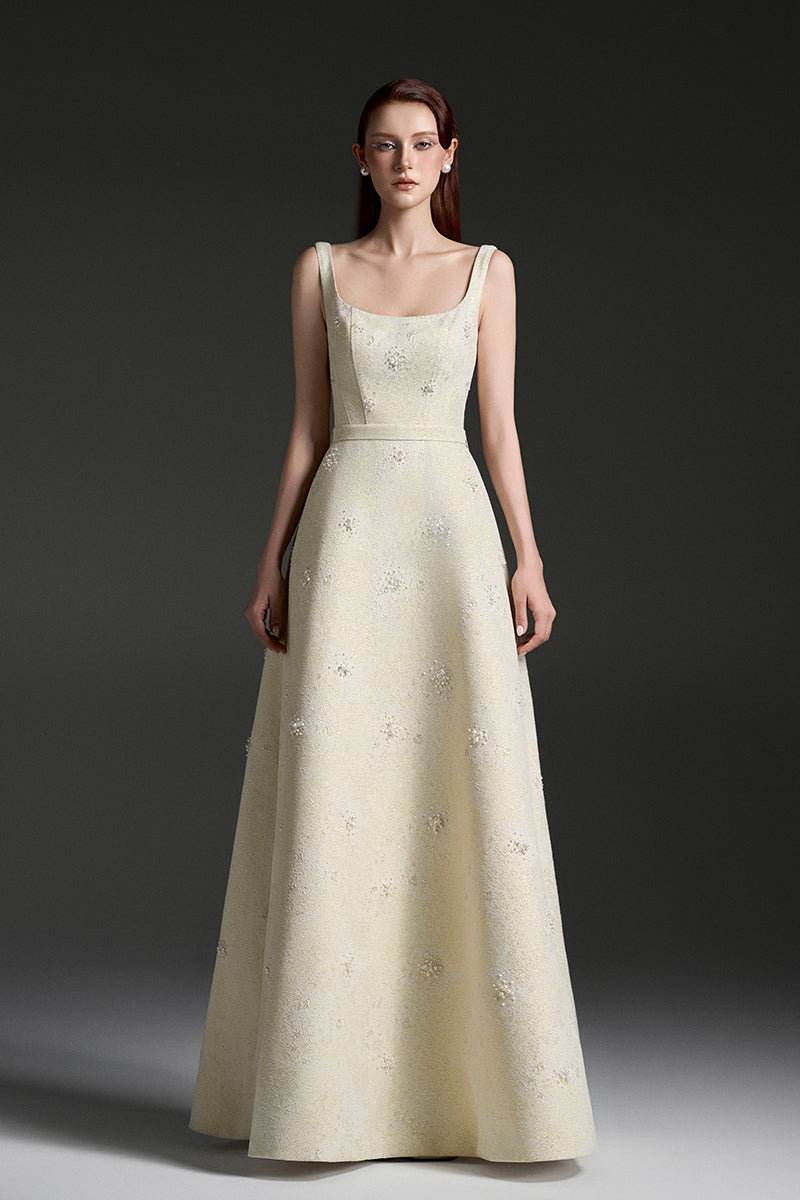 Light yellow silk-lined brocade gown by I.H.F Studio featuring strapless design, A-line silhouette, lacquer finish, and pearl cluster embellishments.
