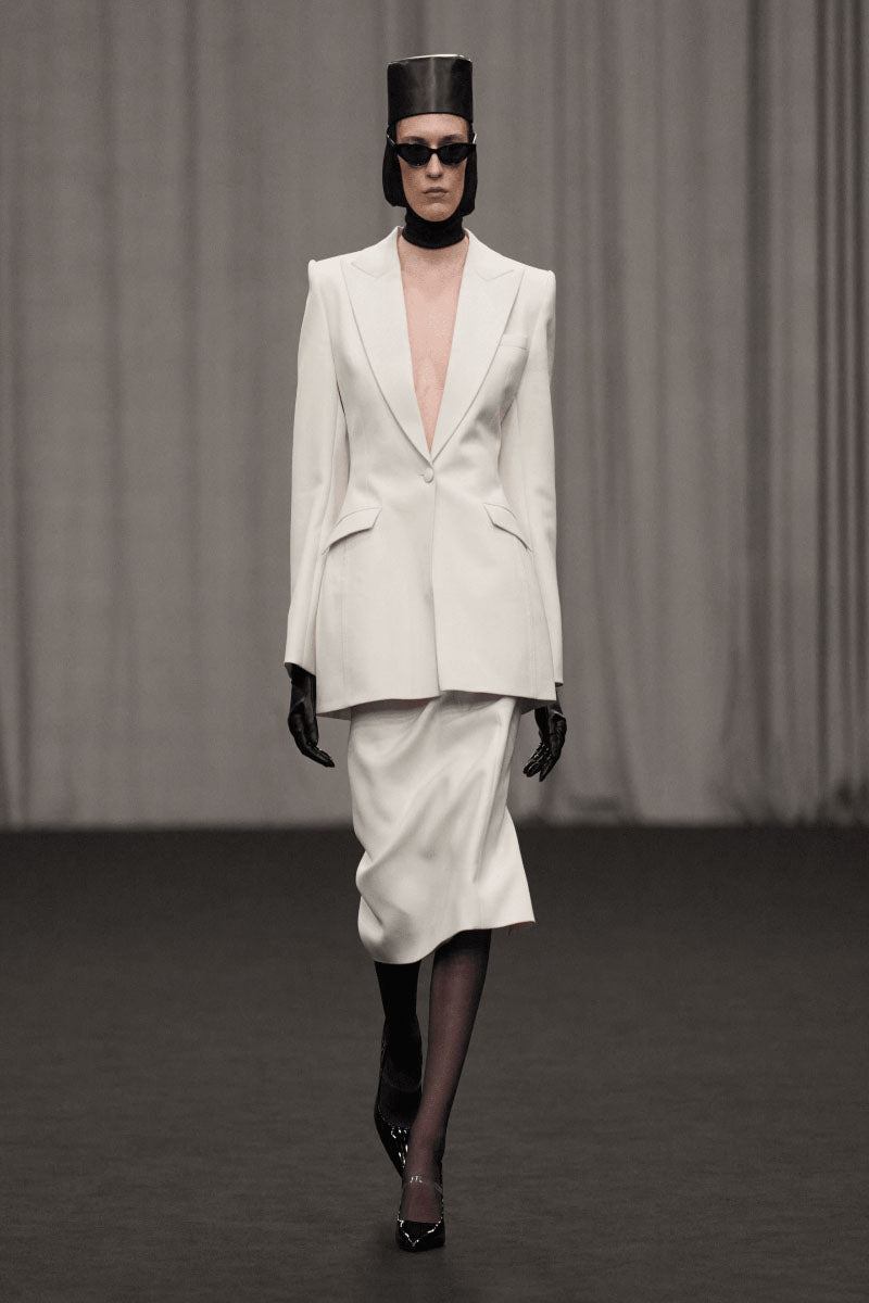 Lili Blanc classic midi length pencil skirt in neutral fabric, shown on model with side slit and fitted waist design.