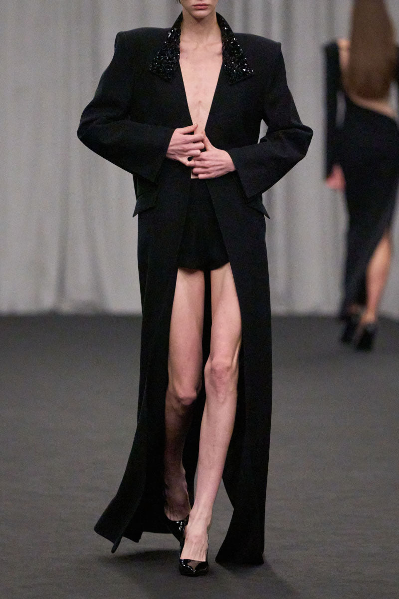 Lili Blanc oversized tailored coat in neutral fabric, shown on a hanger with detailed lapels and structured design.