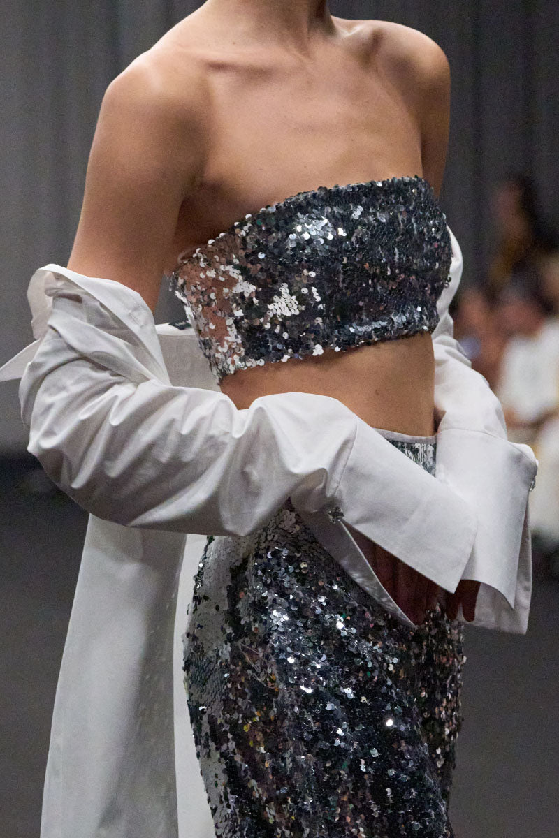 Lili Blanc sequin fitted crop top in vibrant color, featuring a sleeveless design and shimmering sequin embellishments.
